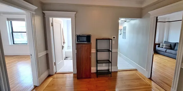 a view of a kitchen with refrigerator and wooden floor