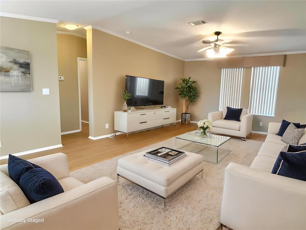 6817 Mt Pleasant Road Northeast, Unit 49 St. Petersburg, FL 33702 - Photo 3 of 30 a living room with furniture and a flat screen tv