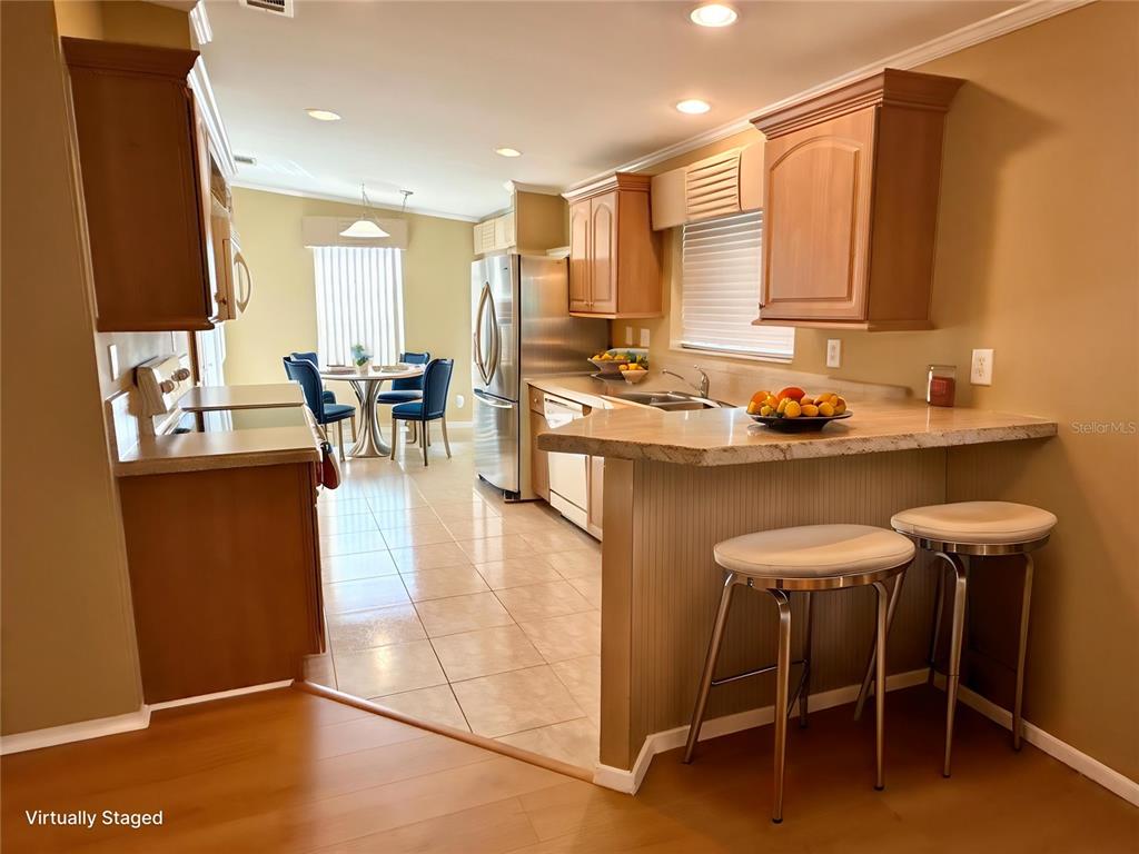 6817 Mt Pleasant Road Northeast, Unit 49 St. Petersburg, FL 33702 - Photo 7 of 30 a kitchen with stainless steel appliances granite countertop table chairs sink and cabinets
