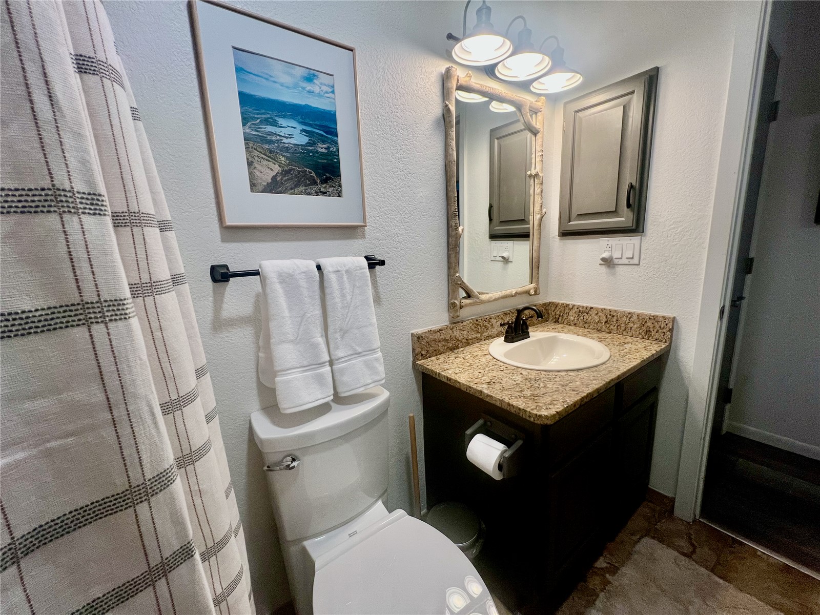 89410 Ryan Gulch Road, Unit 104 Silverthorne, CO 80498 - Photo 11 of 31 a bathroom with a granite countertop toilet sink and mirror