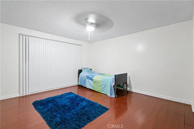 an empty room with wooden floor and ceiling fan