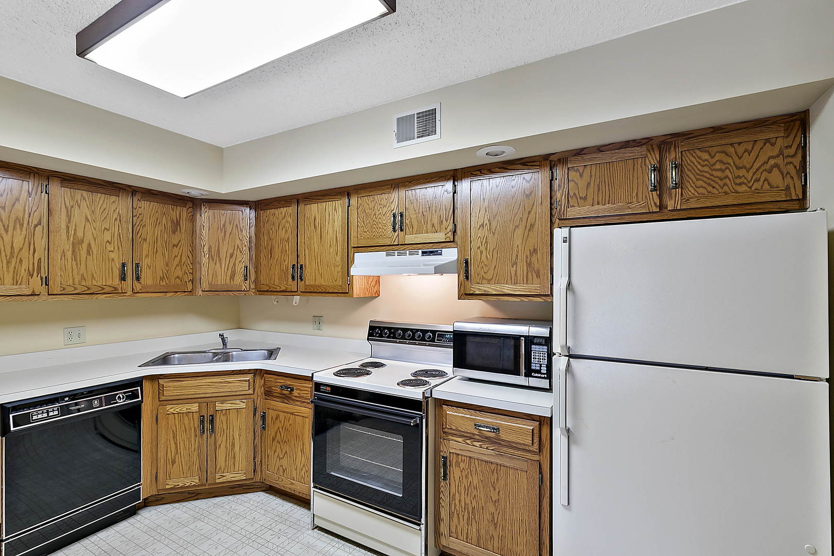 937 East Division Street, Unit 2D Lockport, IL 60441 - Photo 4 of 18 a kitchen with stainless steel appliances granite countertop a refrigerator a stove a sink and a microwave