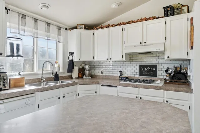 a kitchen with granite countertop a stove sink and cabinets