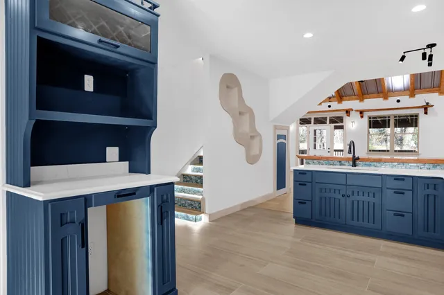 a view of a living room kitchen with furniture and wooden floor