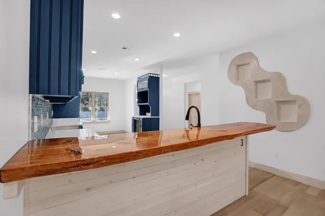 a kitchen with kitchen island granite countertop a sink and a stove top oven