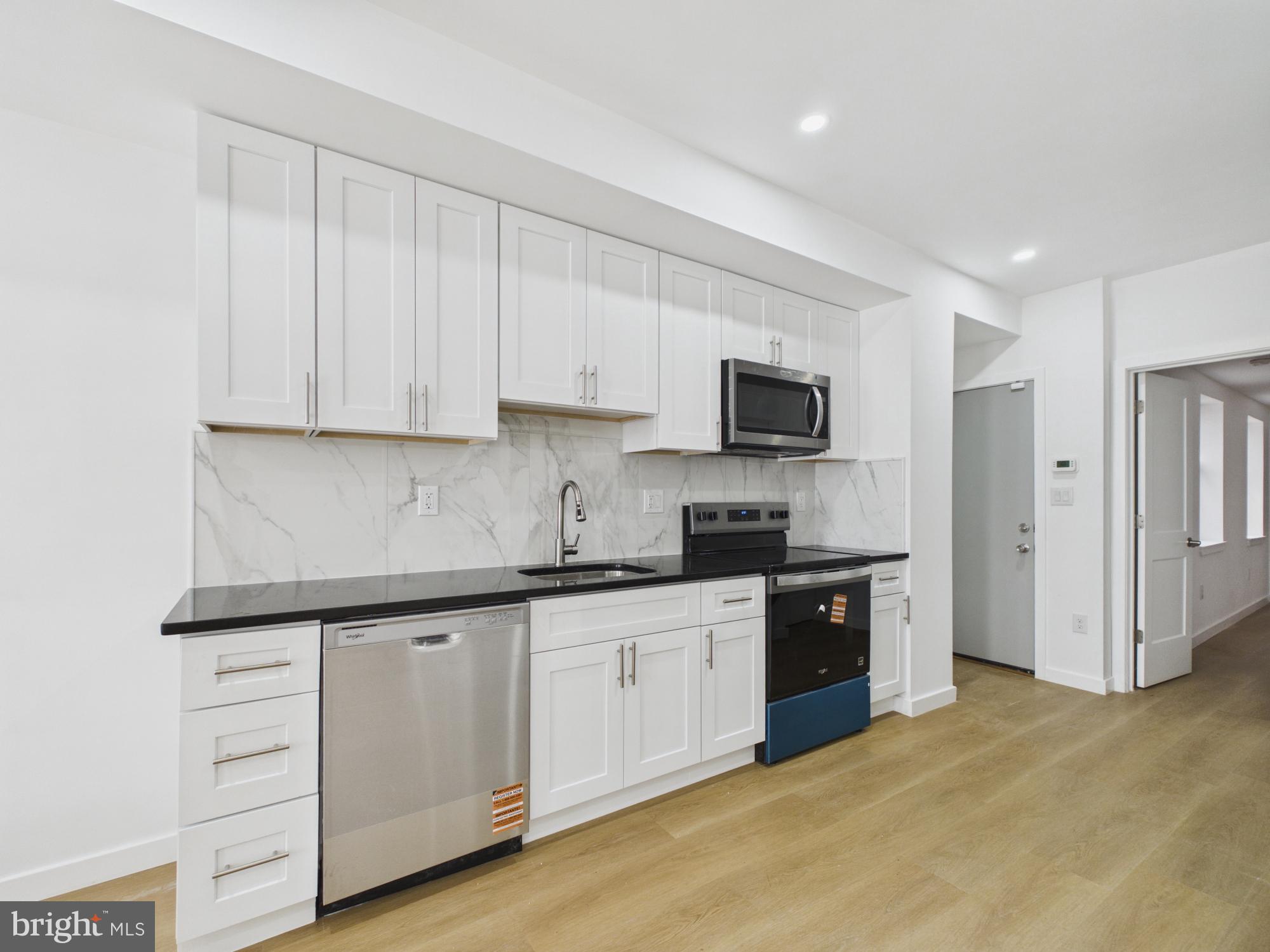 3629 Warren Street Philadelphia, PA 19104 - Photo 1 of 17 a kitchen with granite countertop white cabinets and stainless steel appliances