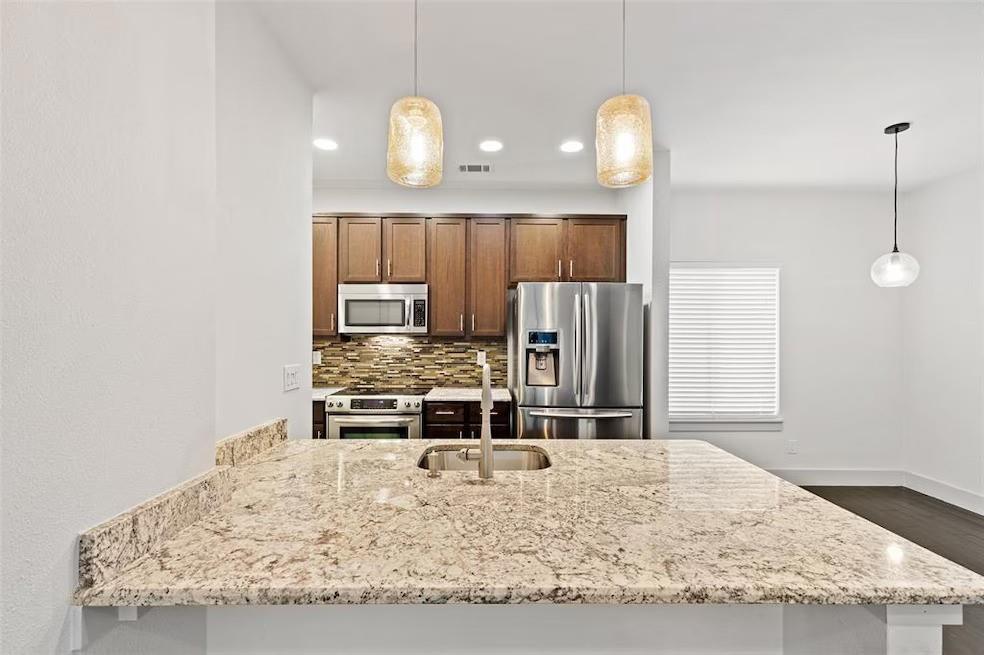 5924 Hudson Street, Unit F Dallas, TX 75206 - Photo 3 of 25 a kitchen with kitchen island a counter top space appliances and cabinets