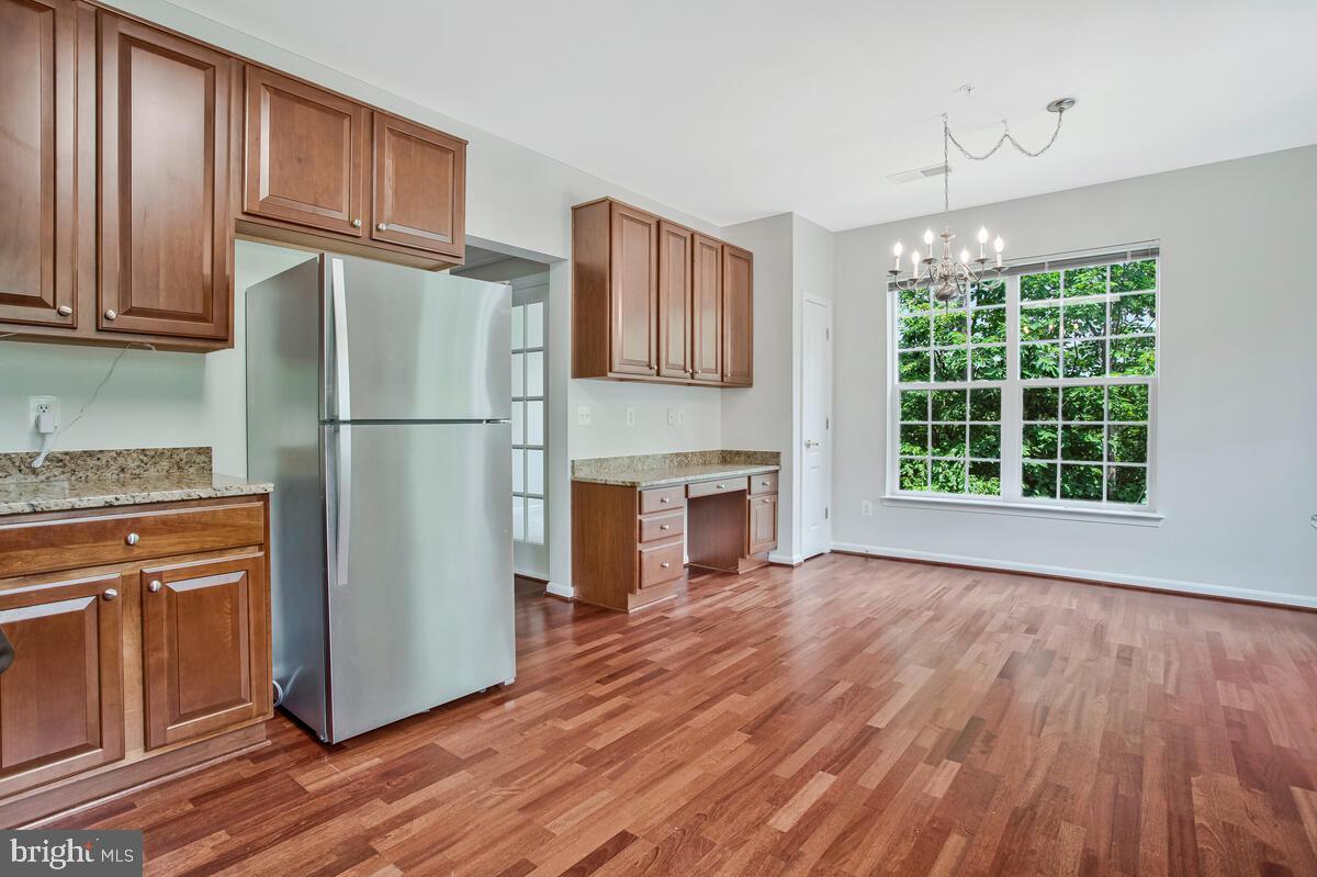 7305 Maplecrest Road, Unit 206 Elkridge, MD 21075 - Photo 18 of 62 a kitchen with granite countertop wooden floors stainless steel appliances and a window