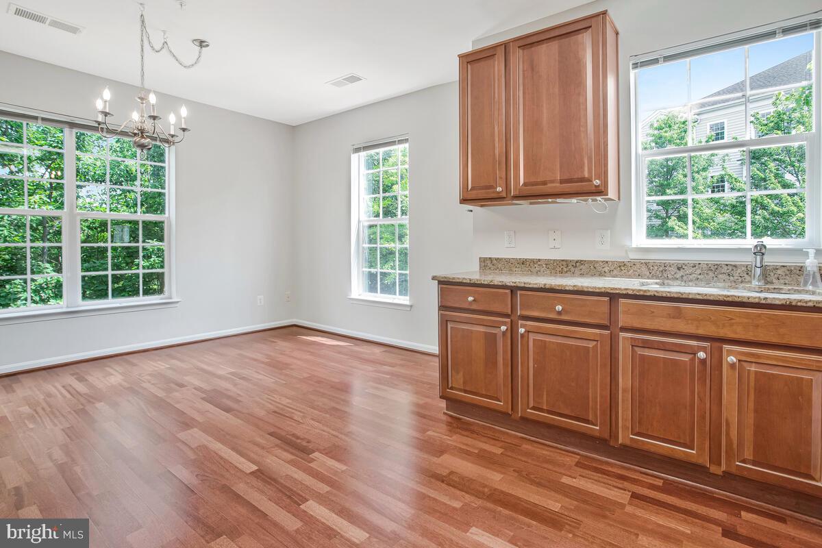 7305 Maplecrest Road, Unit 206 Elkridge, MD 21075 - Photo 19 of 62 a kitchen with granite countertop wooden floors and wide window