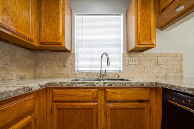 a kitchen with granite countertop stainless steel appliances a sink and cabinets