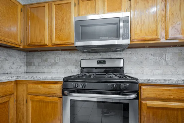 a kitchen with stainless steel appliances granite countertop cabinets and a stove top oven