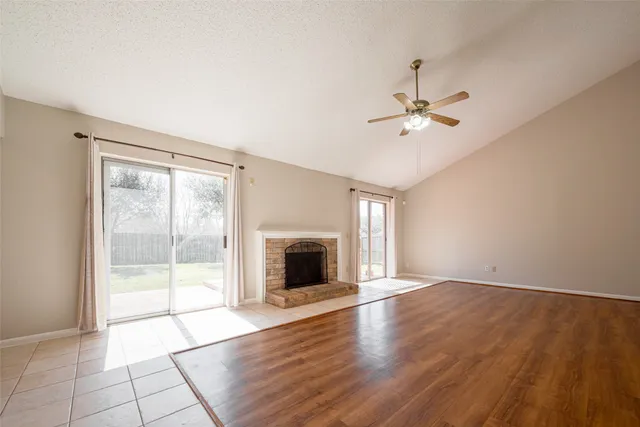 wooden floor fireplace and windows in an empty room