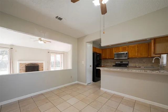 a kitchen with stainless steel appliances granite countertop a sink window and cabinets