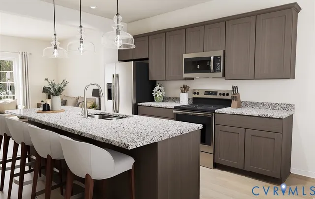 a kitchen with kitchen island granite countertop a sink and a refrigerator