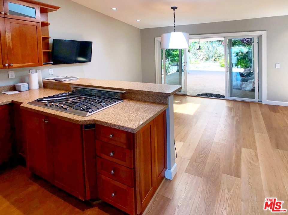 18325 Coastline Drive Malibu, CA 90265 - Photo 8 of 20 a kitchen with a stove a sink and a wooden floor