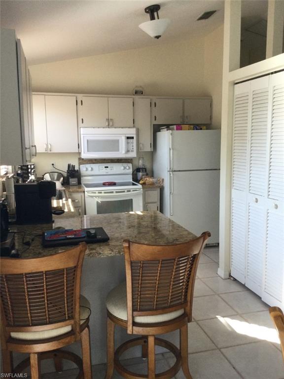 8414 Bamboo Road Fort Myers, FL 33967 - Photo 4 of 5 a kitchen with a dining table chairs and refrigerator