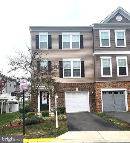 a front view of a house with yard and parking