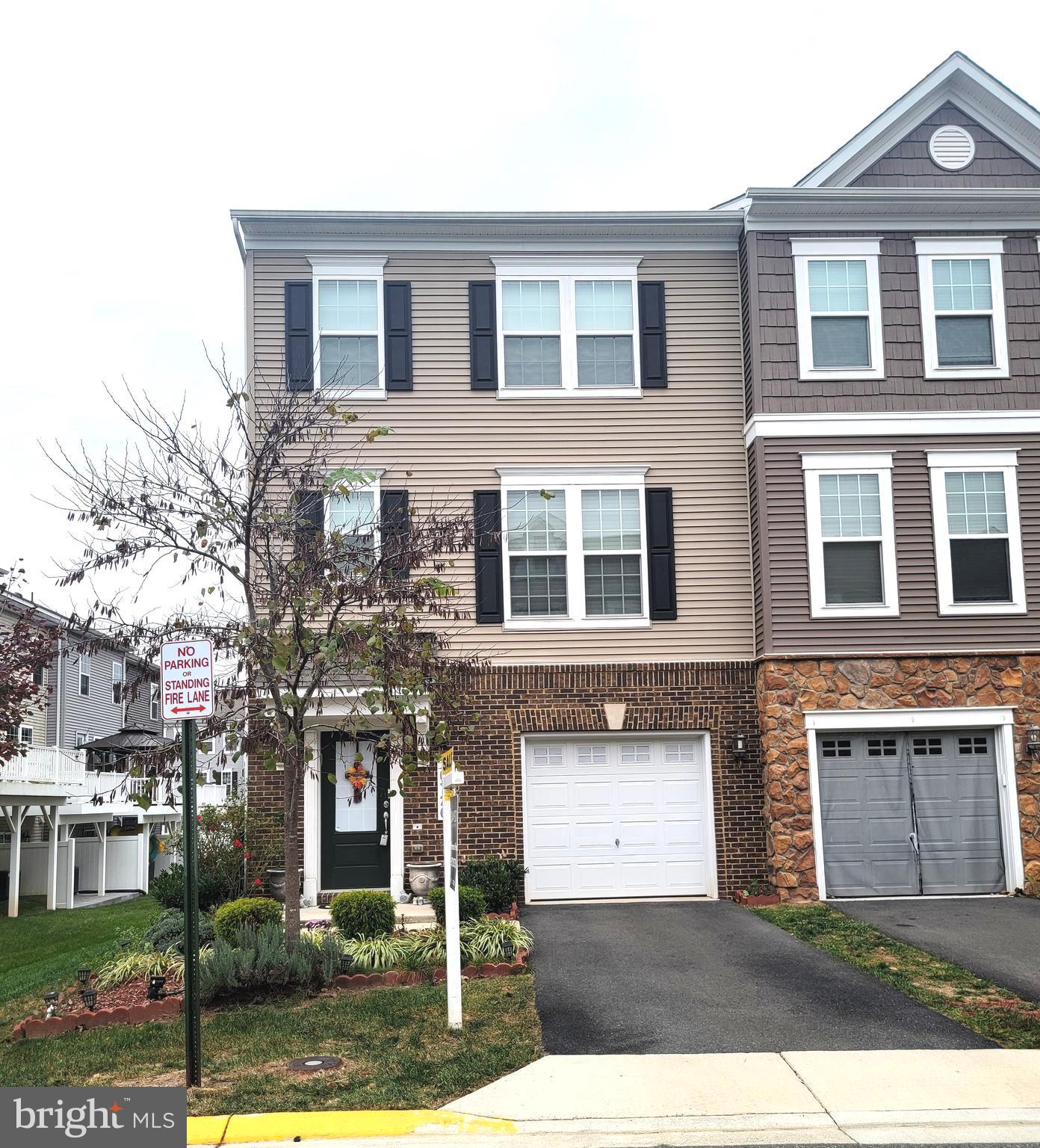 a front view of a house with yard and parking