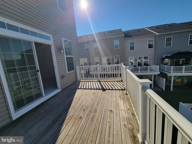 a view of a roof deck with couches and wooden floor