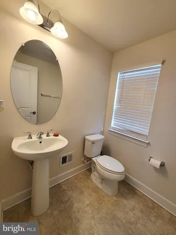 a bathroom with a sink a toilet and mirror
