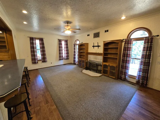 a living room with stainless steel appliances kitchen island granite countertop furniture and a large window