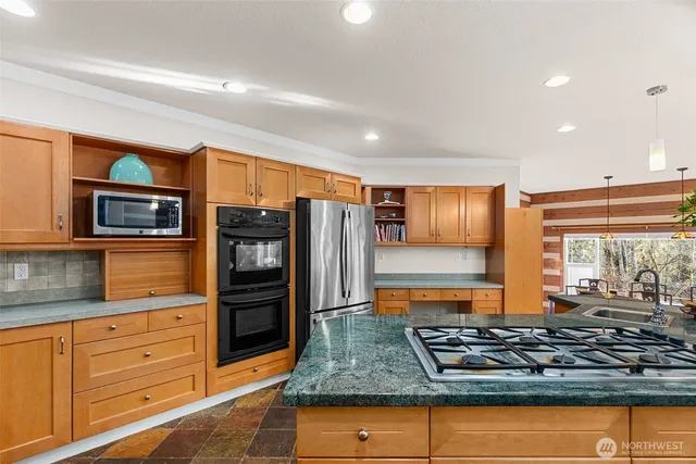 a kitchen with stainless steel appliances granite countertop a stove and a refrigerator