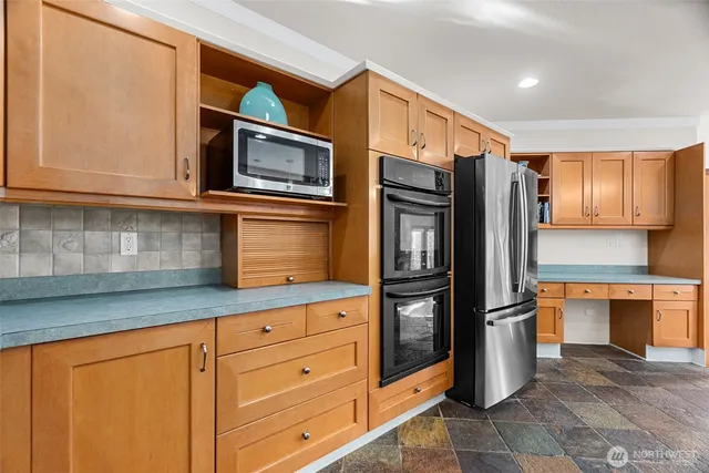 a kitchen with stainless steel appliances granite countertop a refrigerator and a stove top oven