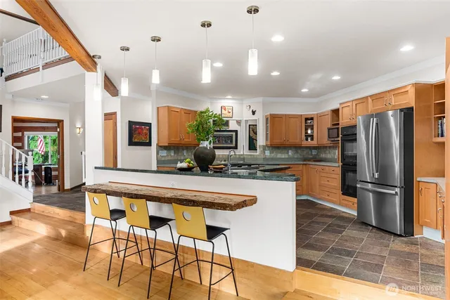 a kitchen with stainless steel appliances kitchen island granite countertop a refrigerator and a stove top oven