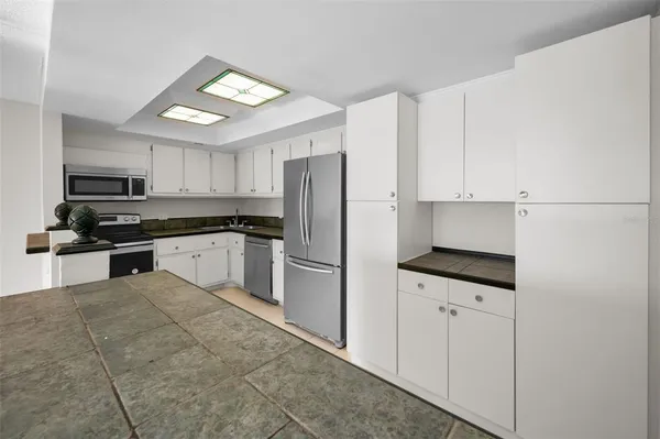 a kitchen with granite countertop white cabinets and stainless steel appliances