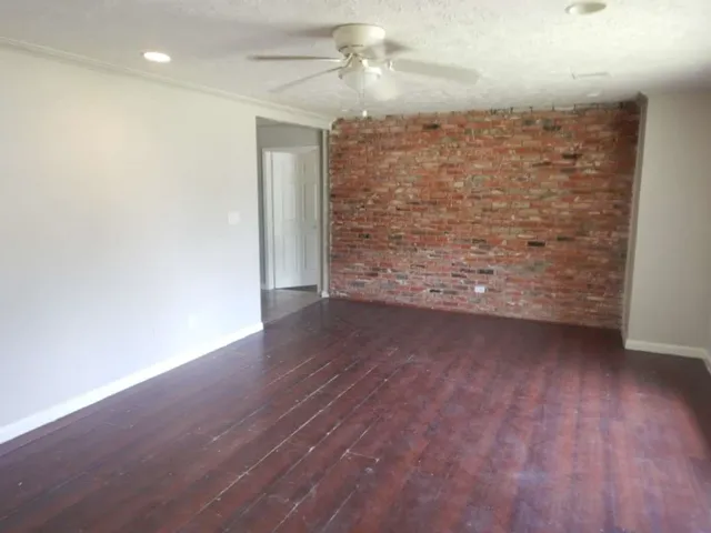 a view of a livingroom with wooden floor and a ceiling fan
