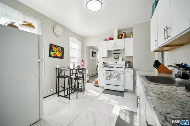 a kitchen with stainless steel appliances a stove a sink and a refrigerator