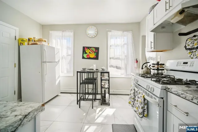 a kitchen with stainless steel appliances a stove a sink cabinets and a refrigerator