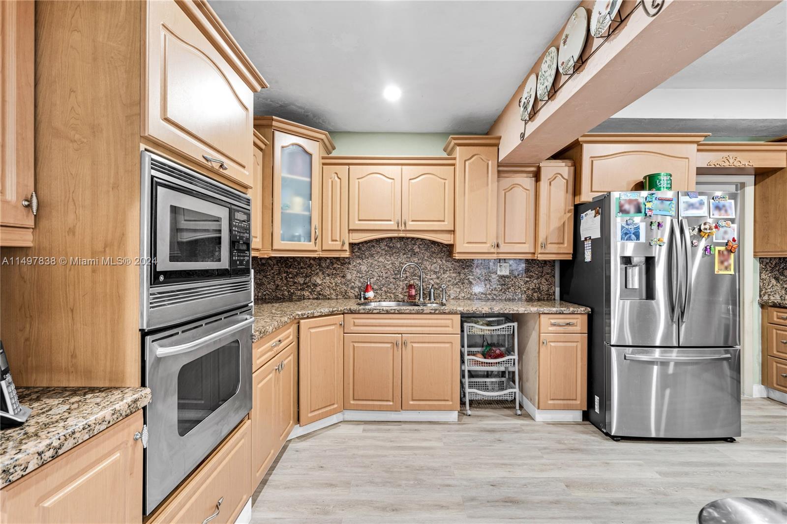 10981 Southwest 44th Street Miami, FL 33165 - Photo 15 of 52 a kitchen with stainless steel appliances granite countertop a stove a sink and a refrigerator