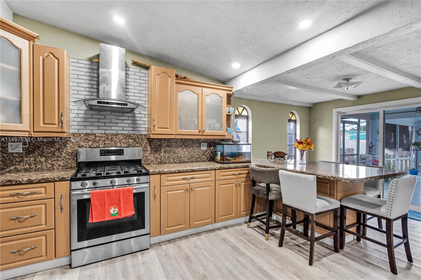 10981 Southwest 44th Street Miami, FL 33165 - Photo 16 of 52 a kitchen with stainless steel appliances granite countertop wooden cabinets a stove a sink and a white wooden cabinets