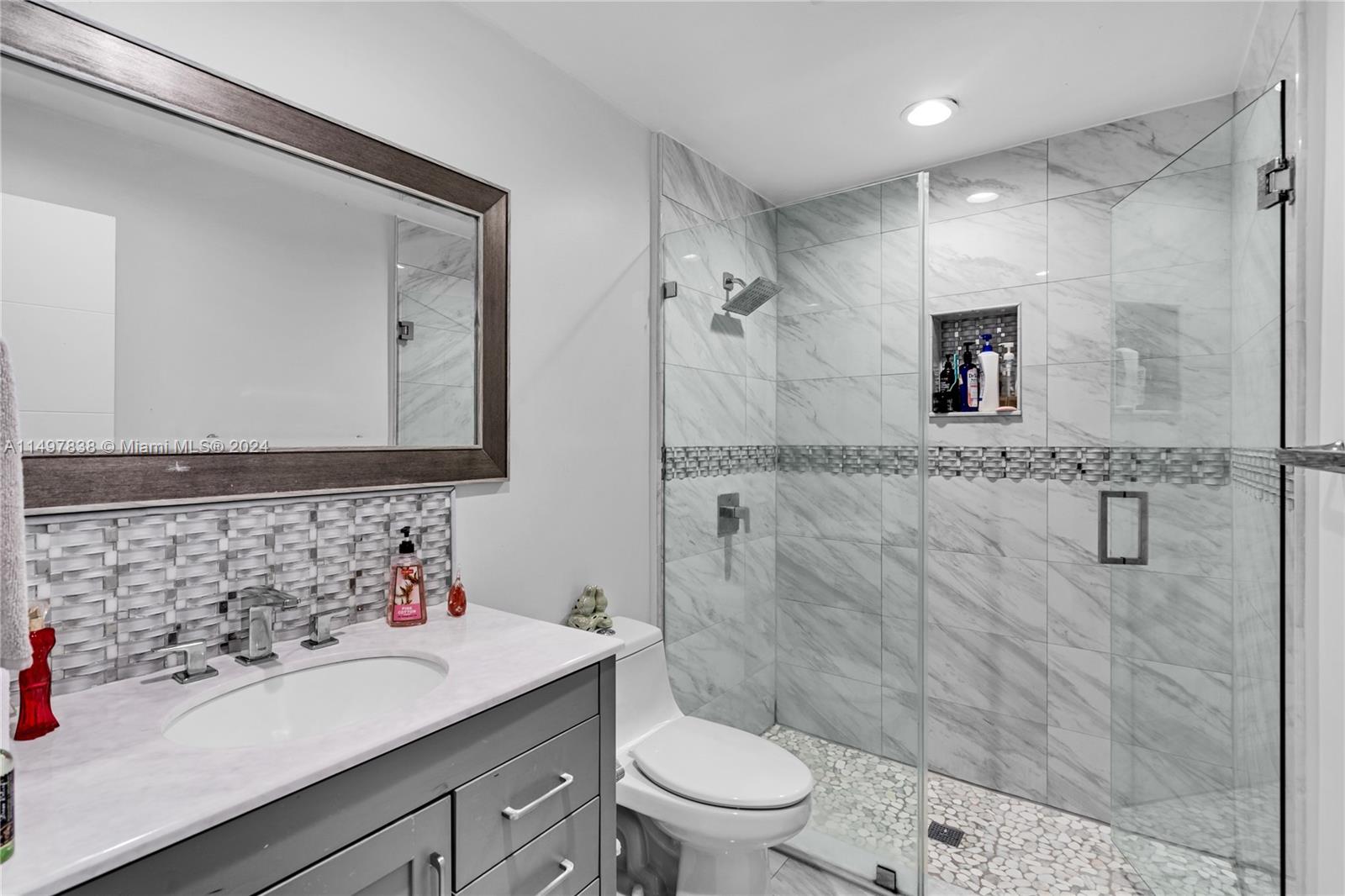 10981 Southwest 44th Street Miami, FL 33165 - Photo 19 of 52 a bathroom with a sink a toilet and shower