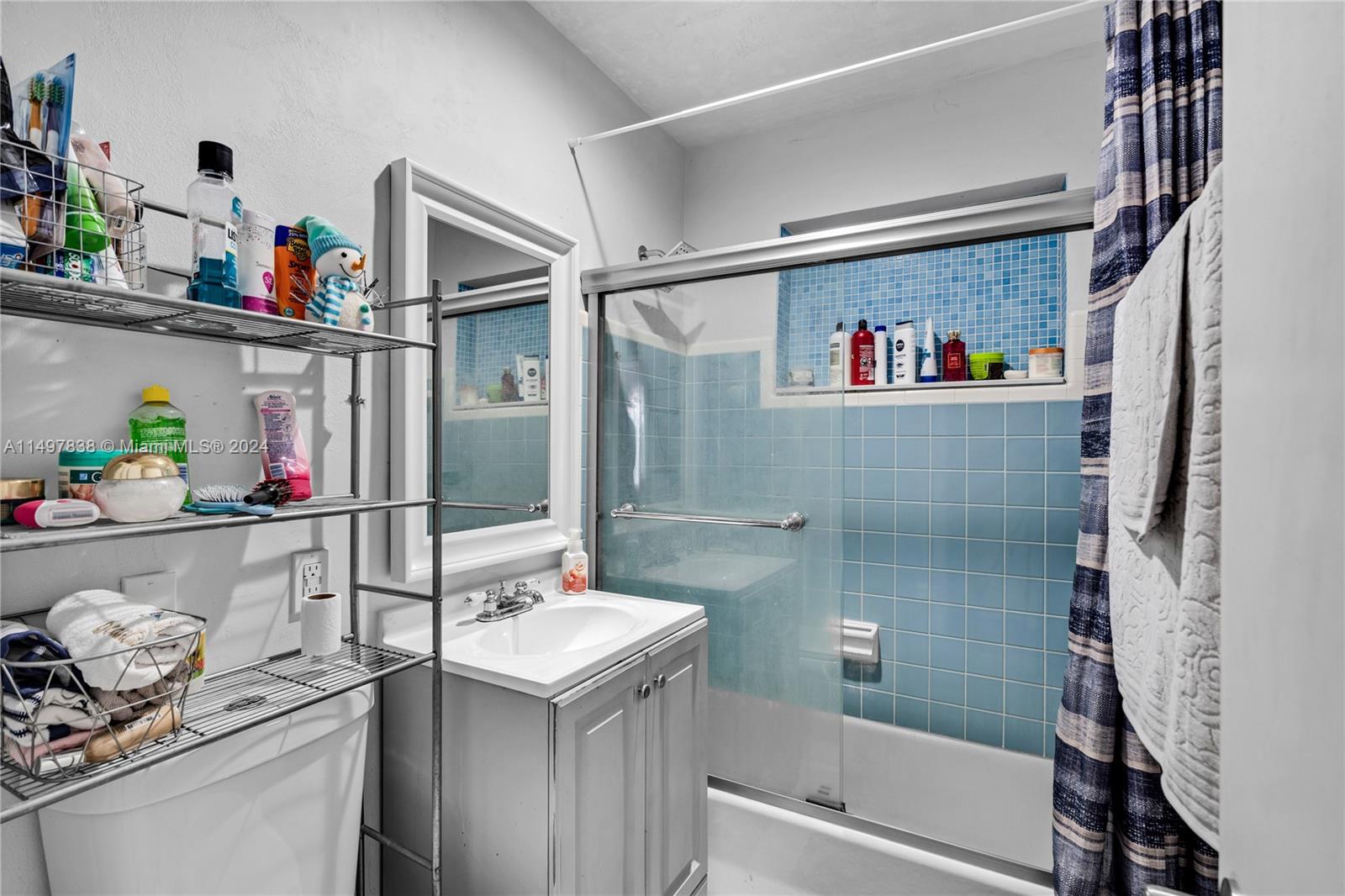 10981 Southwest 44th Street Miami, FL 33165 - Photo 29 of 52 a bathroom with a shower sink and mirror
