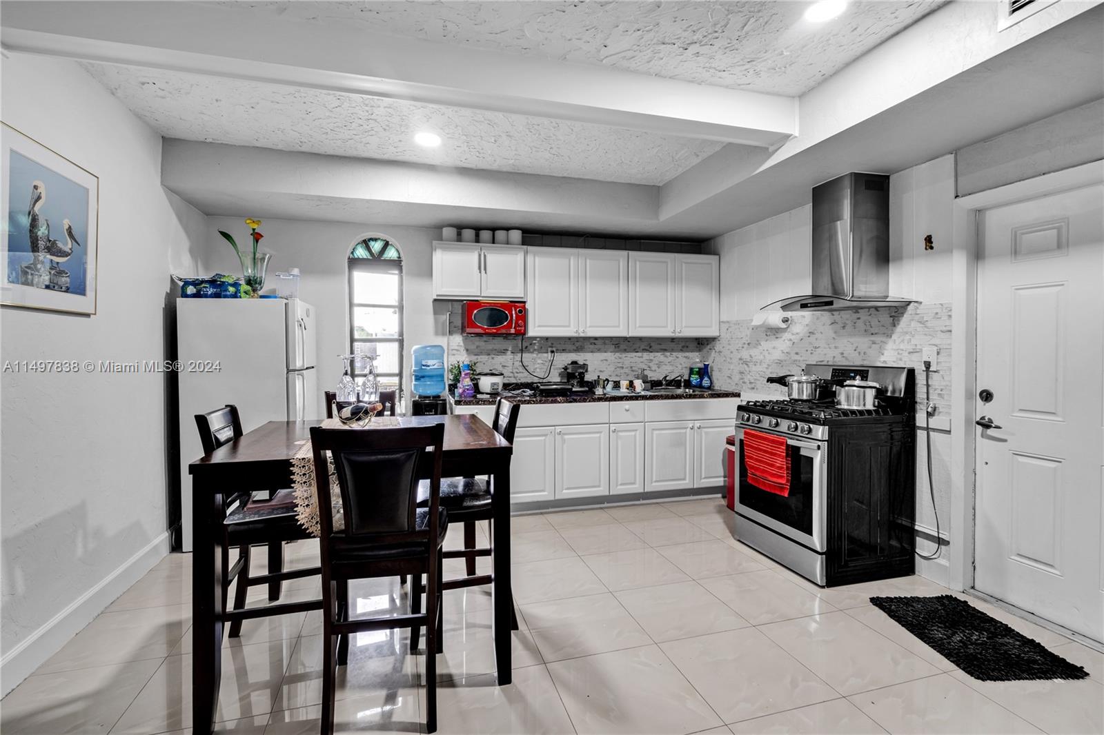 10981 Southwest 44th Street Miami, FL 33165 - Photo 33 of 52 a kitchen with stainless steel appliances a stove a sink dishwasher and a refrigerator
