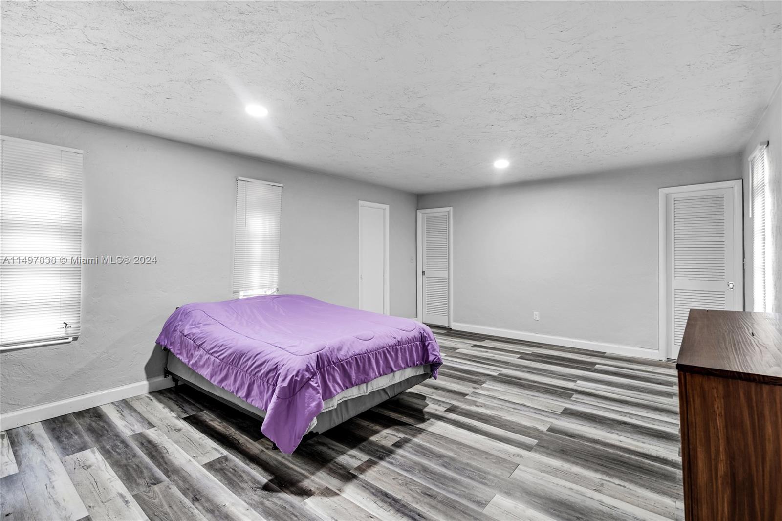 10981 Southwest 44th Street Miami, FL 33165 - Photo 34 of 52 a spacious bedroom with a bed and a flat screen tv