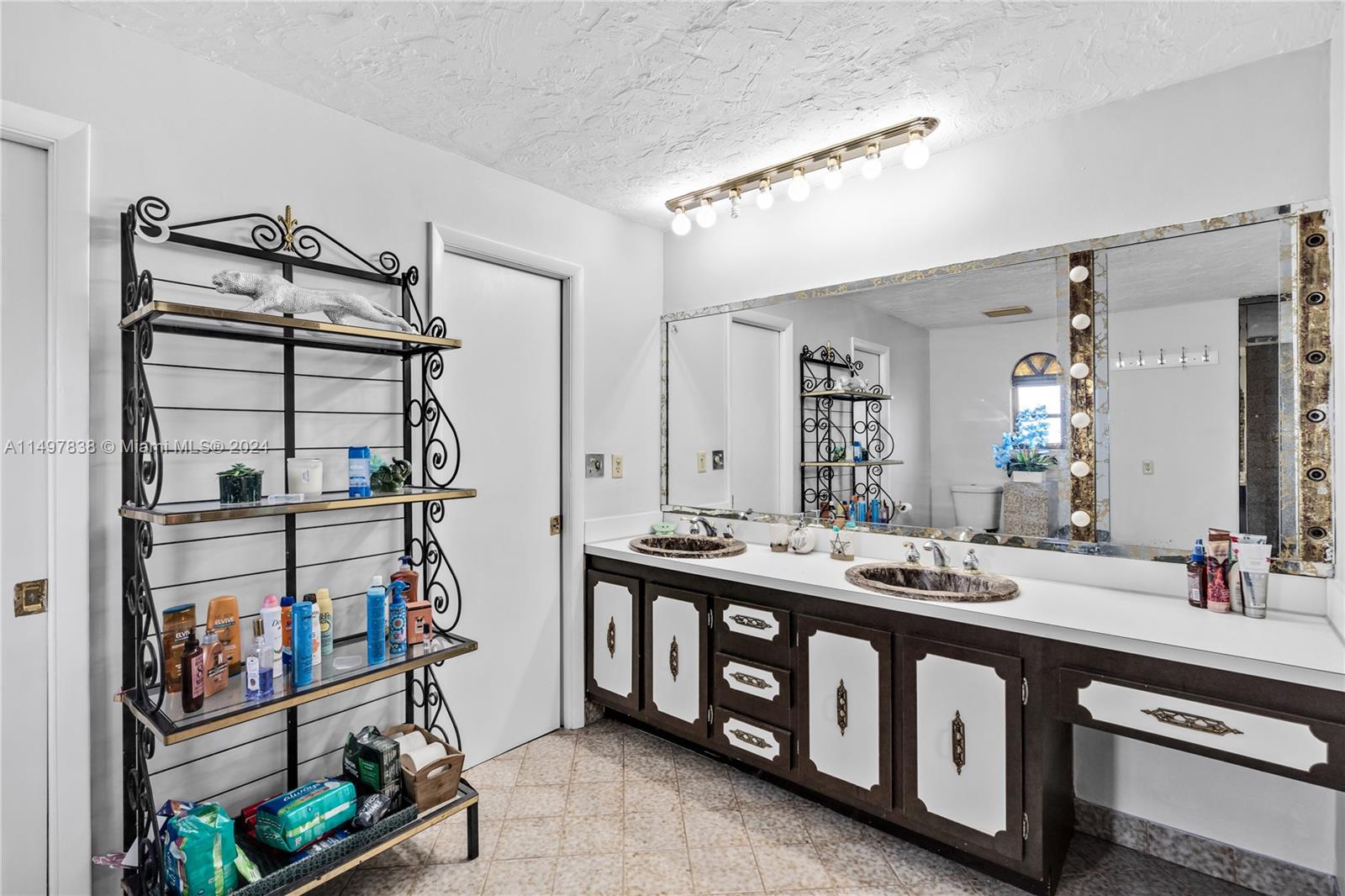 10981 Southwest 44th Street Miami, FL 33165 - Photo 37 of 52 a bathroom with double vanity and a mirror