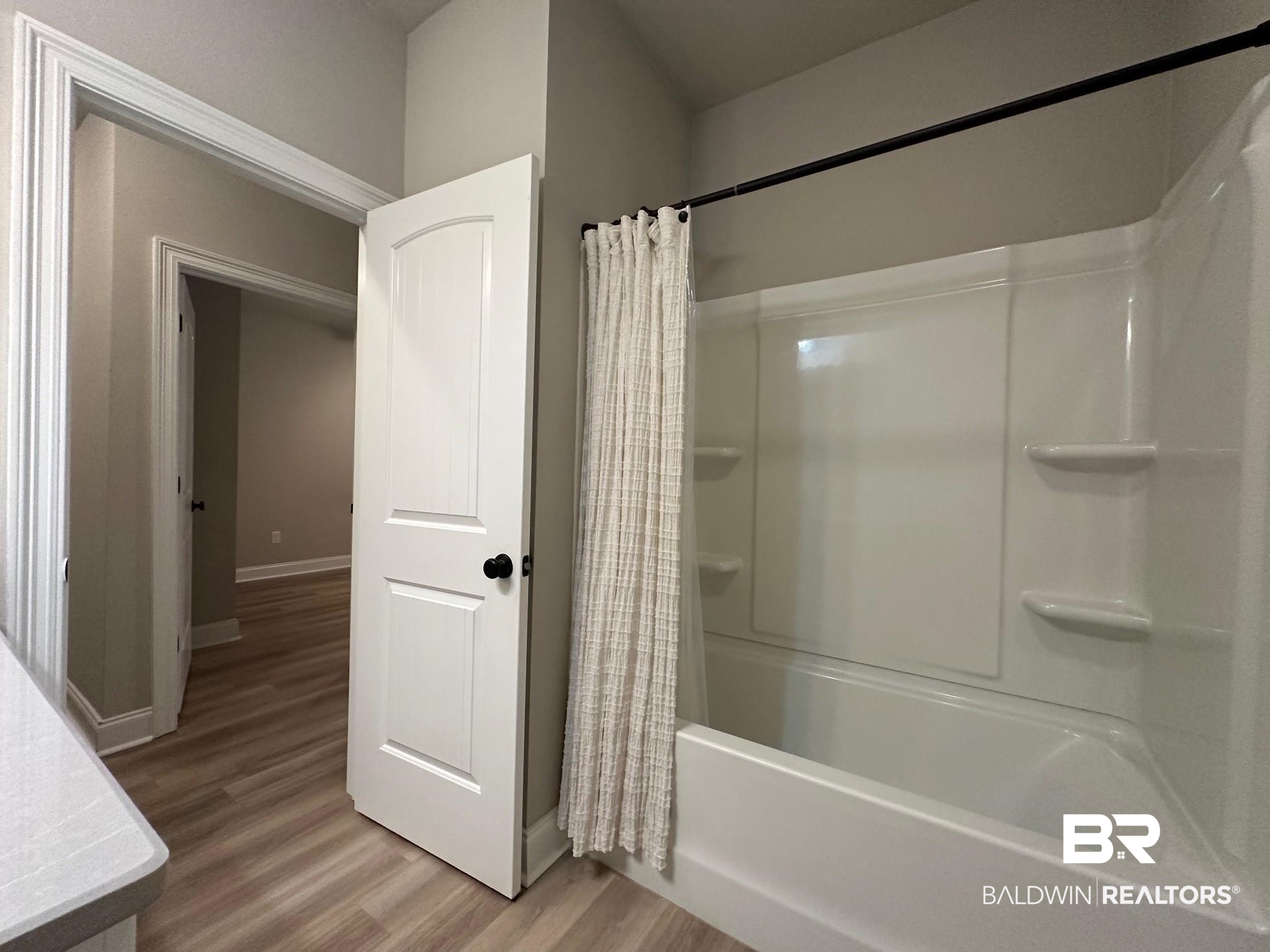1009 Ruisseau Drive Foley, AL 36535 - Photo 50 of 55 Bathroom featuring shower / bathtub combination with curtain and wood-type flooring