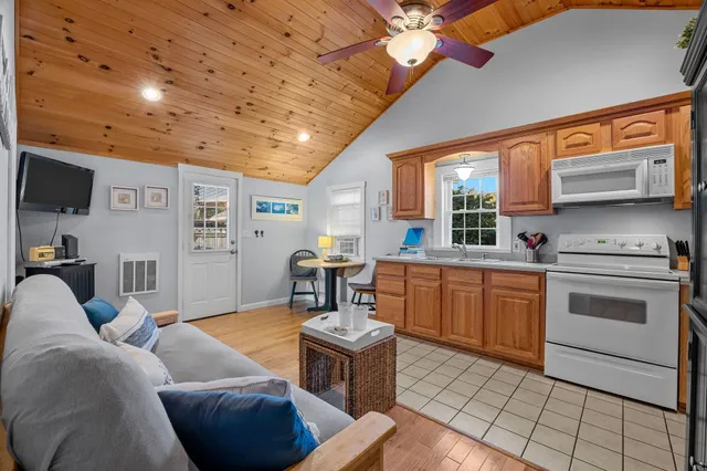 a living room with furniture a flat screen tv and kitchen view