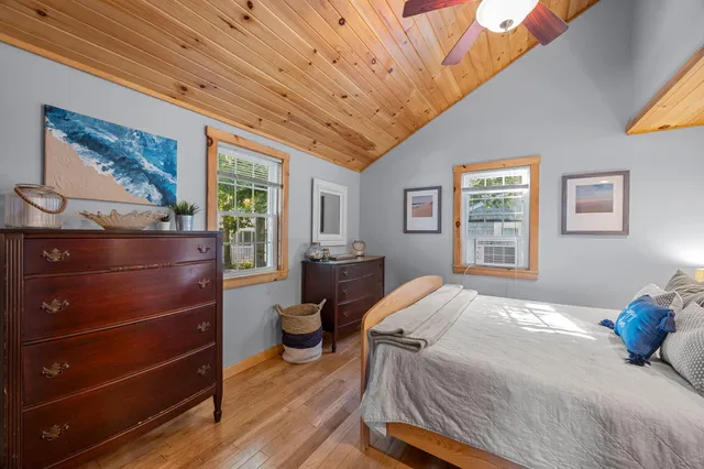 a bedroom with a bed and a dresser next to a window
