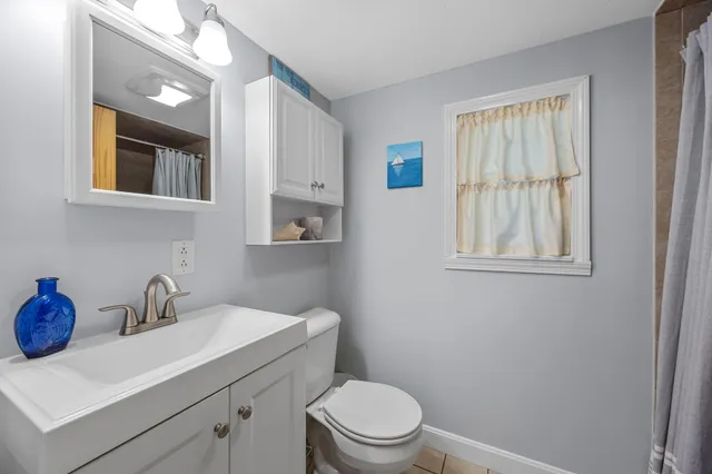 a bathroom with a toilet a sink and mirror