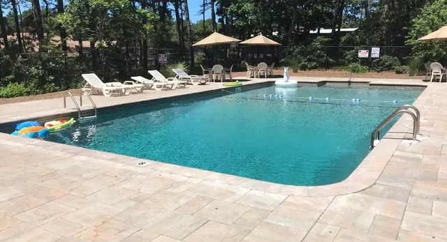 a view of a swimming pool with a table and chairs under an umbrella