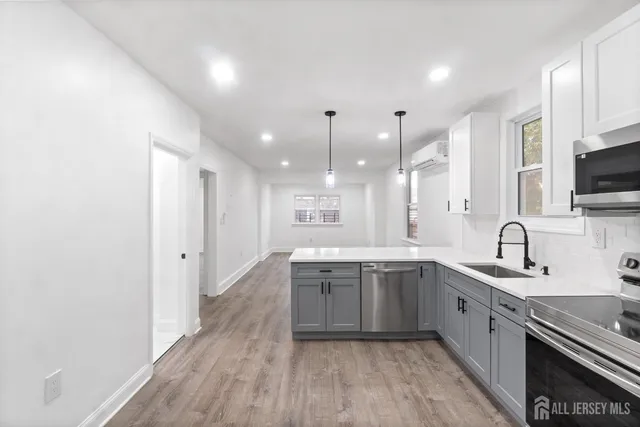a kitchen with stainless steel appliances a refrigerator sink and microwave