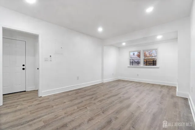 a view of a big room with wooden floor and windows