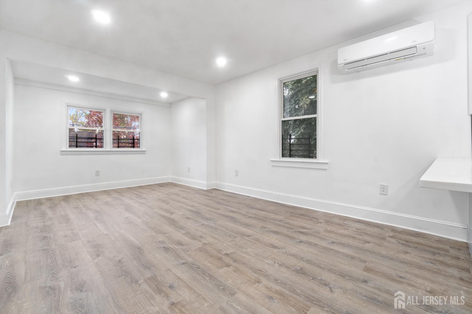 427 Benner Street, Unit 2 Highland Park, NJ 08904 - Photo 8 of 18 a view of a big room with wooden floor and windows