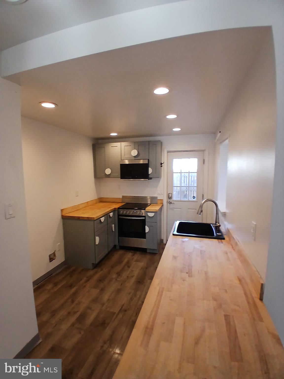 4511 Laird Street Philadelphia, PA 19139 - Photo 4 of 20 a large white kitchen with sink stove and cabinets