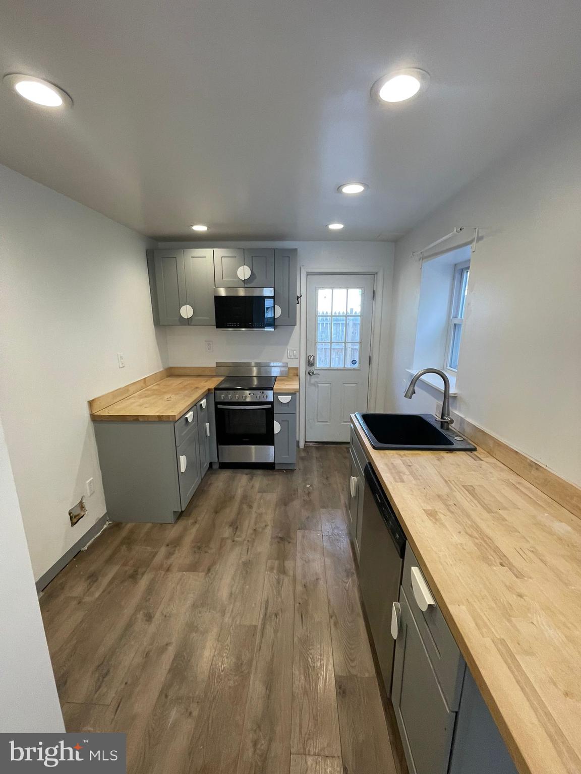 4511 Laird Street Philadelphia, PA 19139 - Photo 5 of 20 a large white kitchen with a stove a sink and a refrigerator