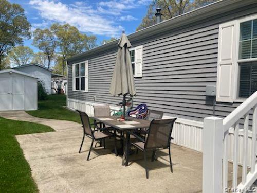 1661 Old Country Road, Unit 49 Riverhead, NY 11901 - Photo 4 of 11 a backyard of a house with table and chairs